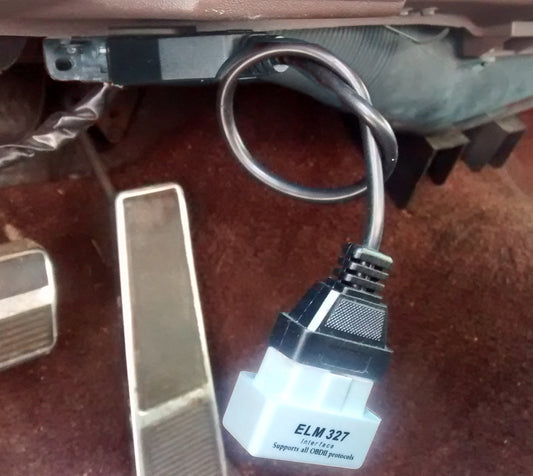OBD-II scanner plugged into a GM vehicle diagnostic port