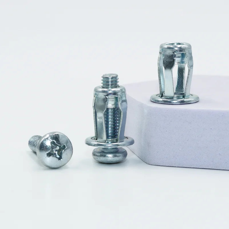 A GripNut anchor and its M4 screw beside a panel edge, with an unset anchor behind