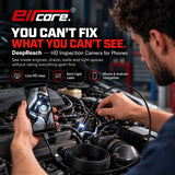 Two hands at an engine bay, one holding the phone with the live view and one steering the lit probe down between the hoses